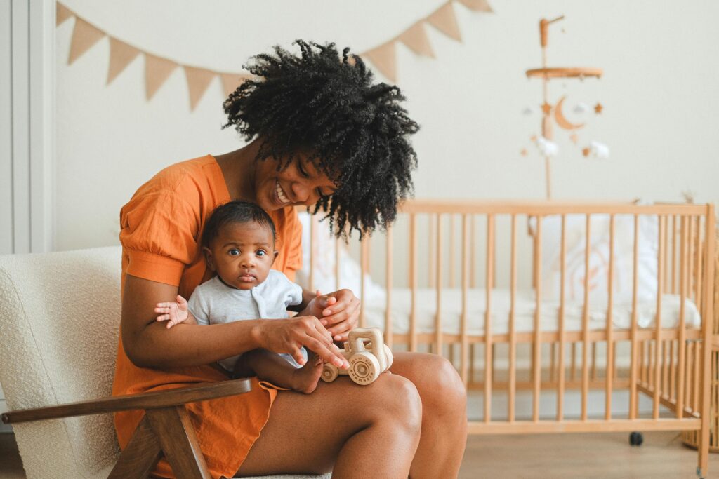 Why Your Baby or Toddler Isn’t Sleeping — Take the Free Sleep Quiz | Otterly Thriving Joyful mother and her baby enjoy playtime in a cozy nursery setting, creating a warm family moment because her baby sleeping on stomach.